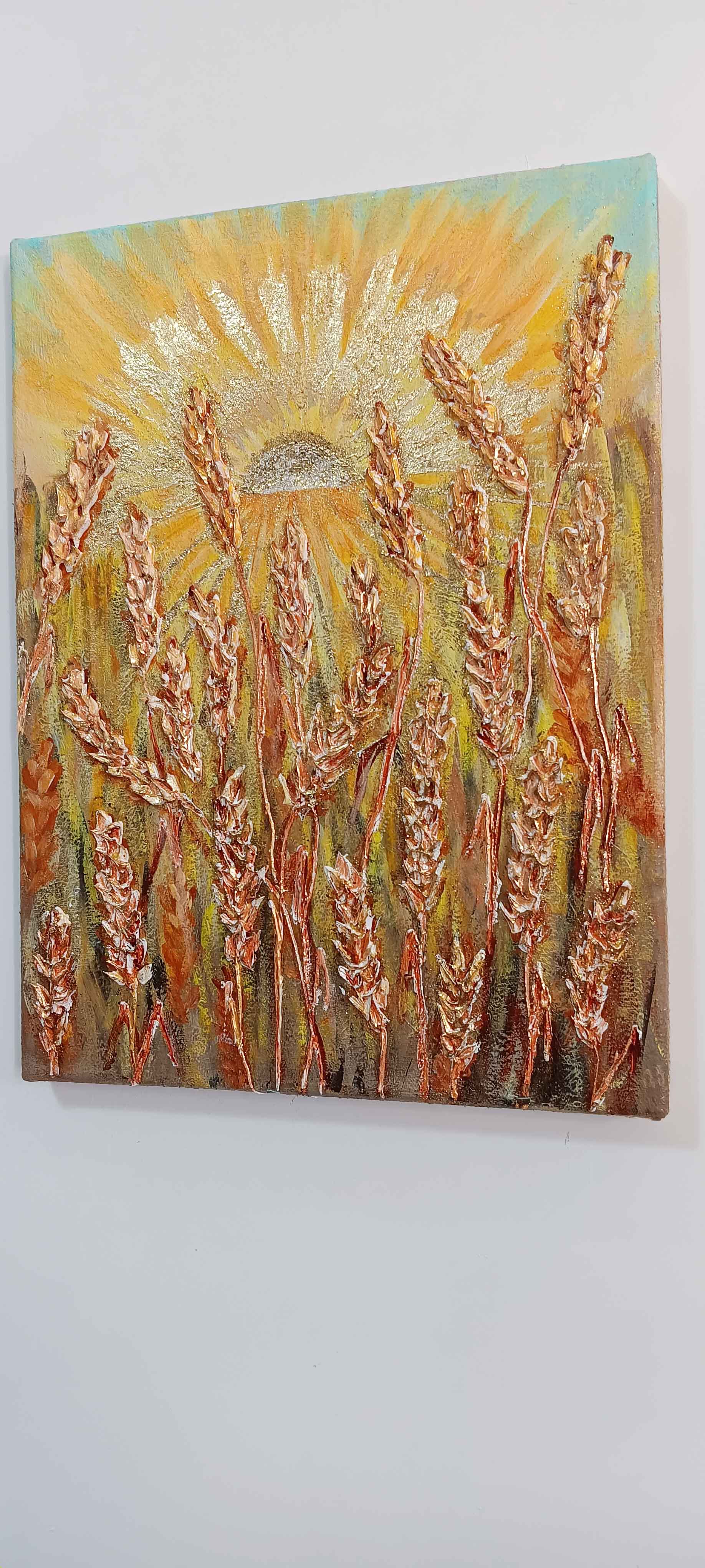 A contemporary 30x40cm vertical painting showing a sun with golden rays rising over a field of wheat. The wheat stalks and sunbeams are created with thick structural paste and gold leaf, giving a 3D effect against a soft sky.