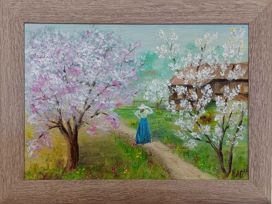 Impressionist oil painting of a woman in a blue skirt walking through a blooming spring garden with a small dog, framed landscape art with pink cherry blossoms.