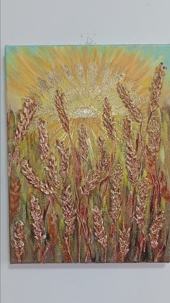 A contemporary 30x40cm vertical painting showing a sun with golden rays rising over a field of wheat. The wheat stalks and sunbeams are created with thick structural paste and gold leaf, giving a 3D effect against a soft sky.